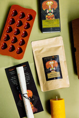 The contents of the Sacred Earth Medicine Chocolate Making Ritual Box - SEM Ceremonial Cacao, organic cacao butter buttons, a sacred hearts chocolate mould, a candle for your ritual, chocolate making instructions and a ritual to consume your chocolates consciously.