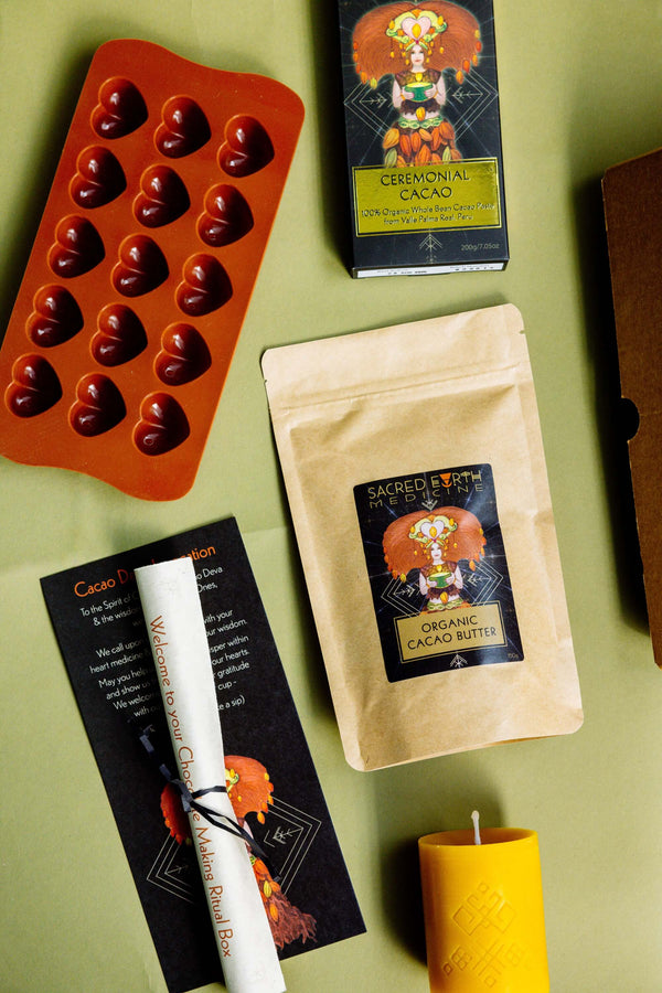 The contents of the Sacred Earth Medicine Chocolate Making Ritual Box - SEM Ceremonial Cacao, organic cacao butter buttons, a sacred hearts chocolate mould, a candle for your ritual, chocolate making instructions and a ritual to consume your chocolates consciously.