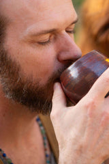 Man taking a sip of a delicious sacred hot chocolate made from Sacred Earth Medicine