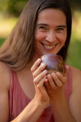 A beautiful woman with a wide open heart and a big smile holding a large size Sacred Earth Medicine cup 