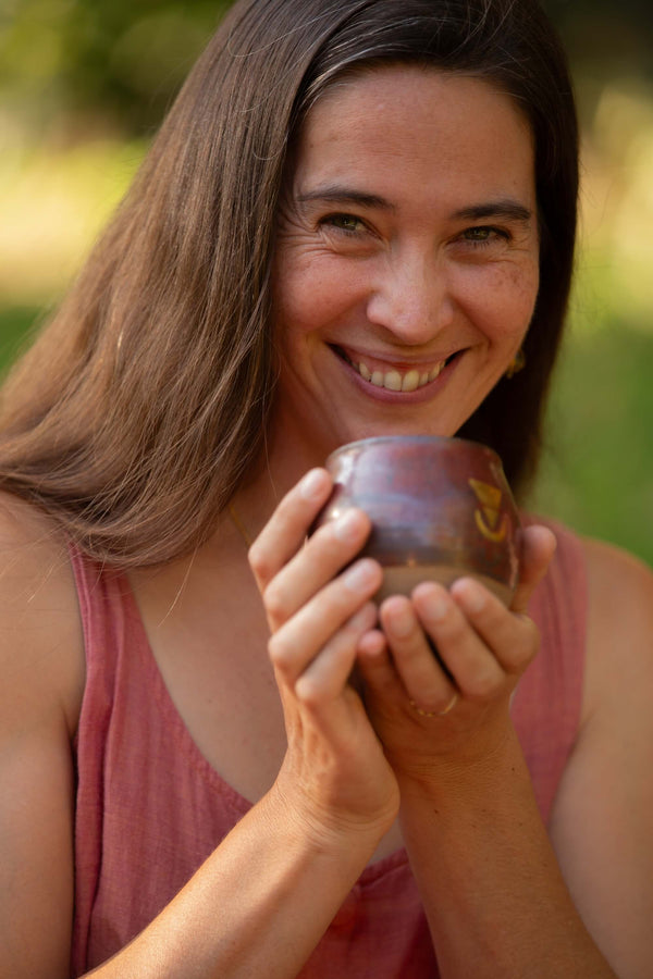 A beautiful woman with a wide open heart and a big smile holding a large size Sacred Earth Medicine ceremonial cup 