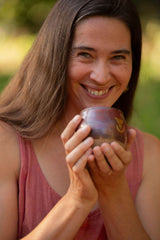 A beautiful woman with a wide open heart and a big smile holding a large size Sacred Earth Medicine cup 