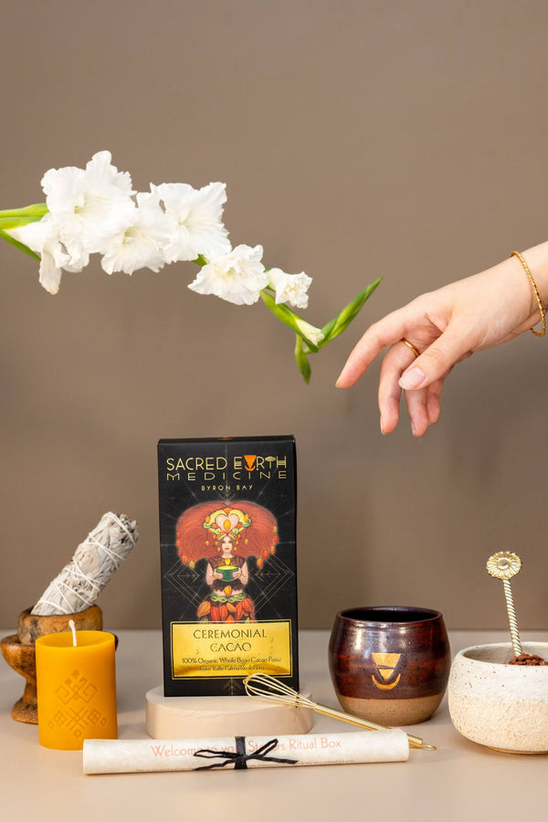 The complete contents of the Sacred Earth Medicine Starters Pack Ritual Box. A 400g block of SEM Ceremonial Cacao, 1 small ceremonial cup, a beeswax candle by Ahana, a sage stick and a scroll to guide your through your very first Ceremonial Cacao experience. This makes a great gift! 
